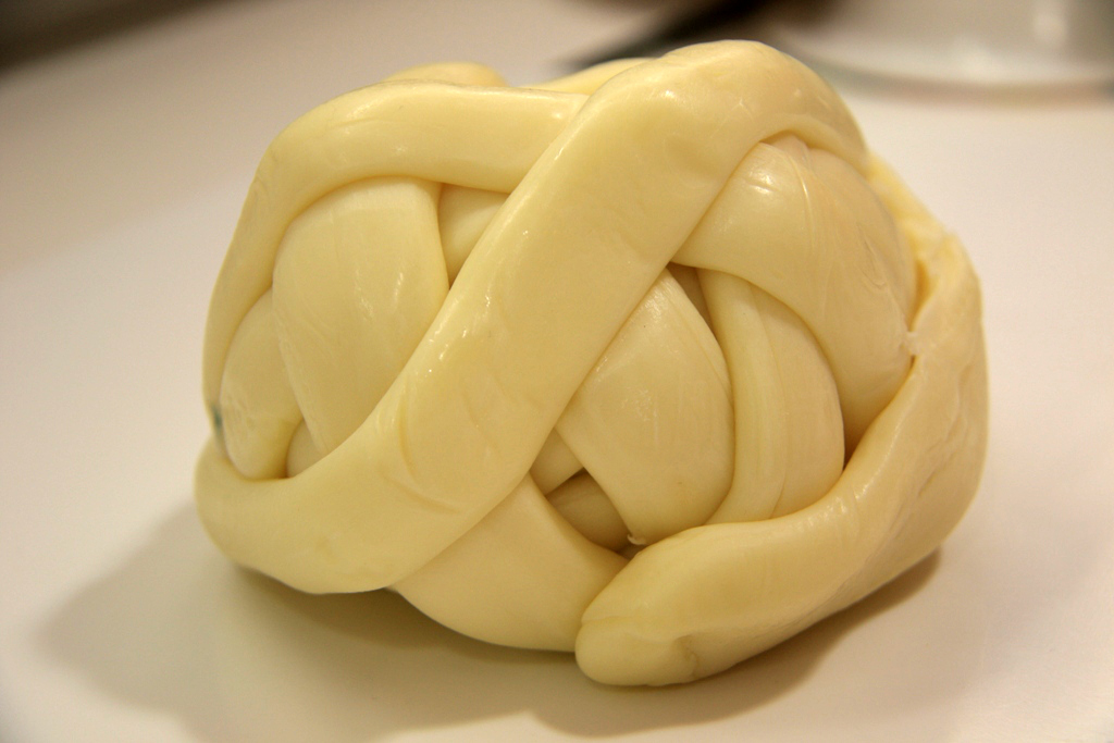 Queso Oaxaca enrollado en bola con hebras visibles